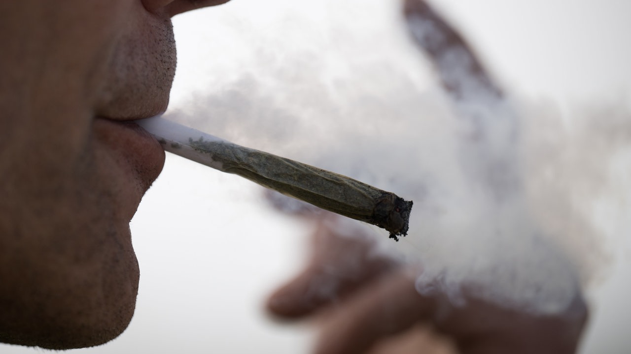 Ein Mann raucht einen Cannabis-Joint.