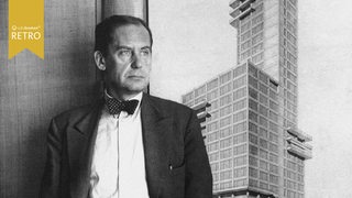Walter Gropius steht 1933 vor seiner Zeichnung für das Chicago Tribune Gebäude
