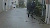 Ein maskierter Mann rennt durch eine Straße.
