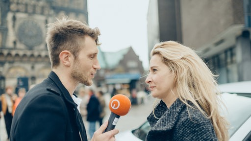 Reporter im Gespräch mit einer Frau