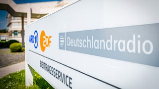 Ein Schild vor einem Gebäude auf dem das Wort Beitragsservice steht.