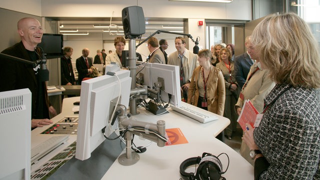 Eine Besuchergruppe betritt ein Radiostudio.