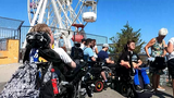 Eine Gruppe von Rollstuhlfahrern vor einem Riesenrad