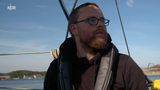 Junger Mann mit Brille auf einem Boot