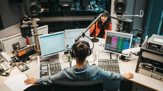 Zwei Frauen sitzen in einem Radio-Studio