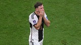 Werder-Stürmer Niclas Füllkrug schlägt sich nach dem WM-Aus in Katar enttäuscht die Hände vors Gesicht.