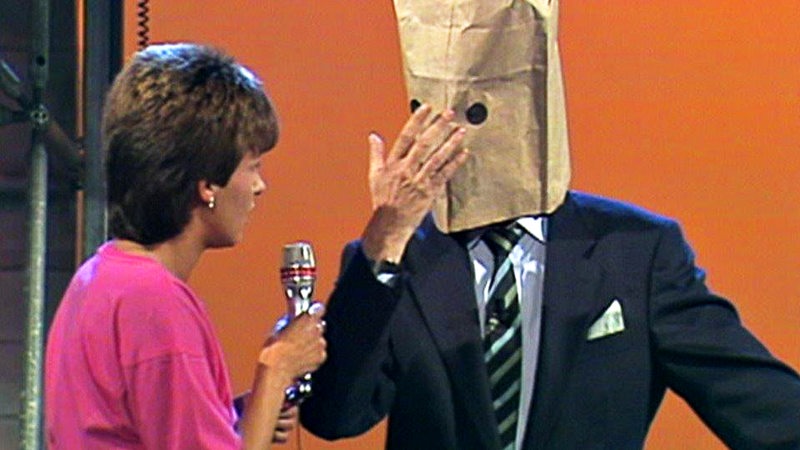 Margarethe Schreinemakers interviewt einen Mann, der eine Papiertüte mit Augenlöchern über den Kopf gestülpt hat.