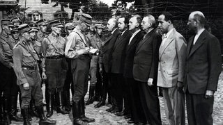 SPD Reichstagsabgeordnete Ernst Heilmann, daneben der Sohn des Reichspräsidenten Ebert, Friedrich Ebert jun. werden von der SA kontrolliert