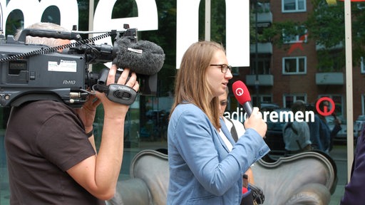 Ein Fernsehteam interviewt eine Person vor dem Radio Bremen-Gebäude
