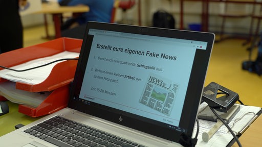Ein Laptop mit dem Satz "Erstellt eure eigenen Fake News"