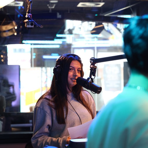 Eine Schülerin steht an einem Mikrofon im Studio