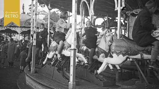 Historisches Bild zeigt Kinder auf einem Kinderkarussell