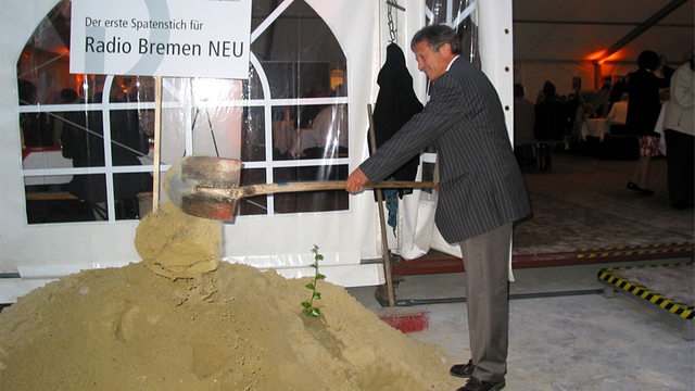 Intendant Glässgen mit einer Schaufel Sand