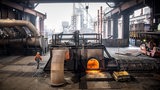 Ein Mann mit einer Arbeitsschutzjacke und einem Helm bekleidet läuft durch eine große Produktionshalle des Bremer Stahlwerks.