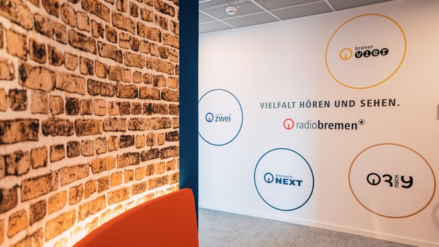 Auf einer Wand steht Vielfalt hören und sehen mit den verschiedenen Logos von Radio Bremen