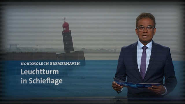 Ein Nachrichtensprecher steht in einem TV-Studio.